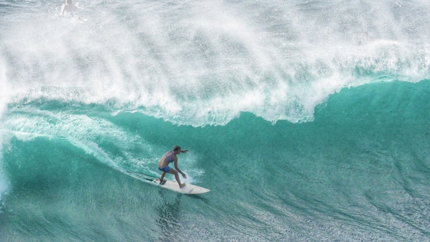 un homme en train de surfer une vague