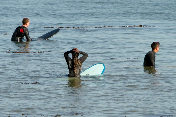 Khadjou Sambe attend la vague aux côtés d'autres surfeurs