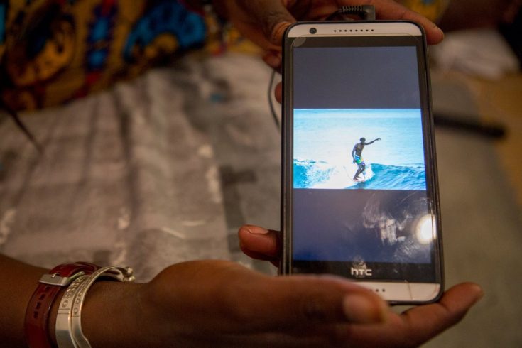 Khadjou Sambe montre une image de surfeur sur son téléphone