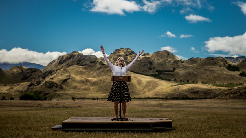 Kristine Tompkins lève les bras sur une estrade au milieu de la pampa