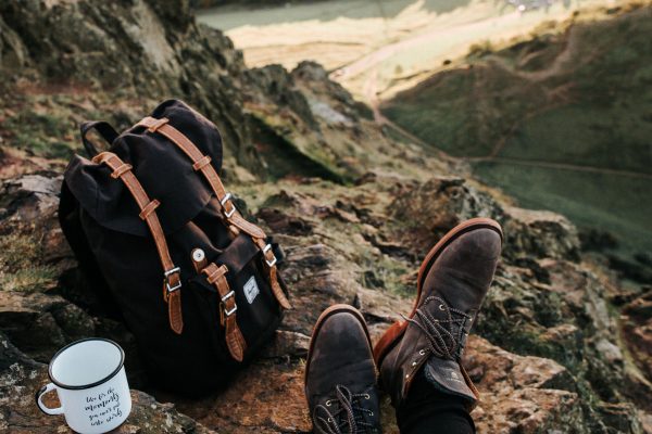 Un voyageur posé en altitude avec son sac à dos