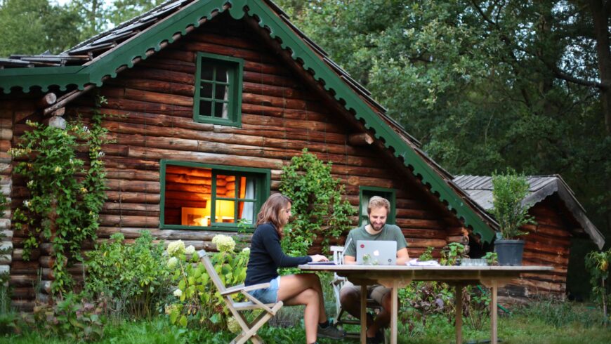 Un couple travaille dehors devant un gîte en bois