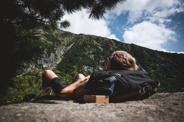 homme à lunettes se repose pendant une randonnée, il est couché