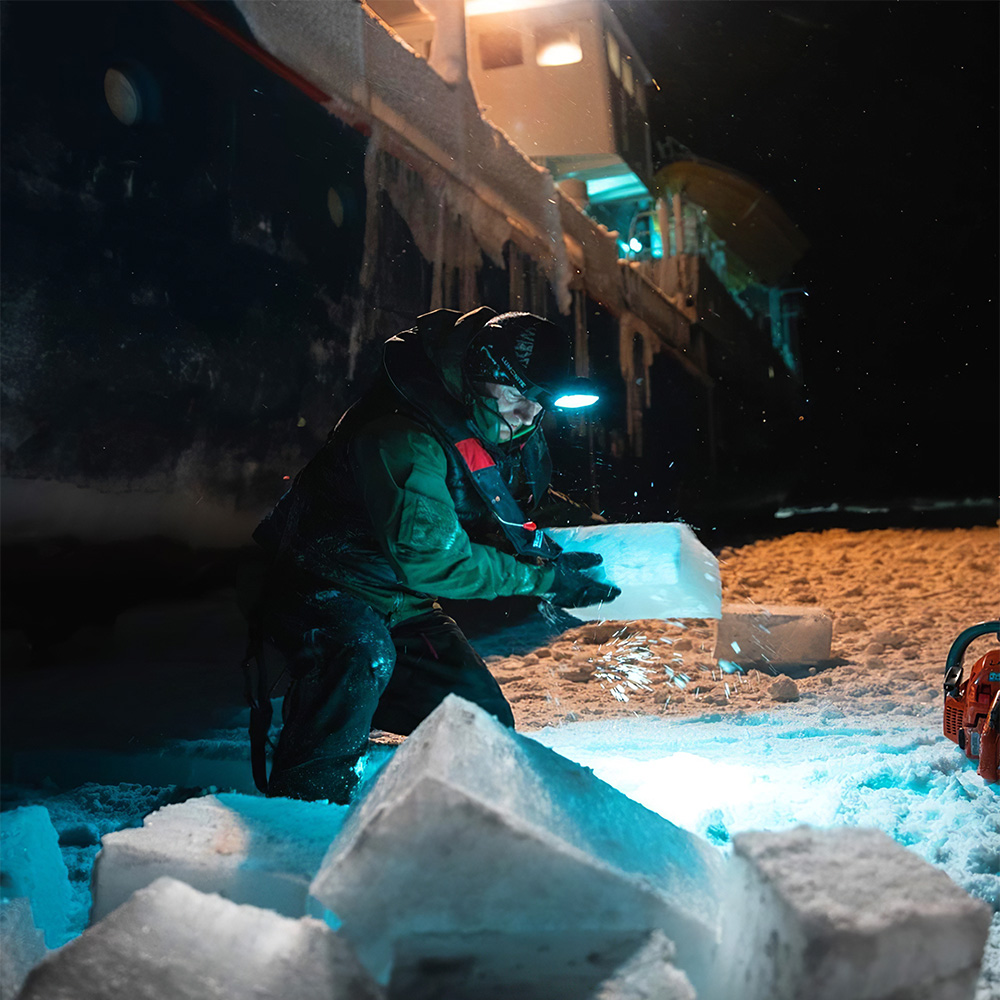 Un membre de l'équipage du Lance travaillant à la libération du navire des eaux gelées