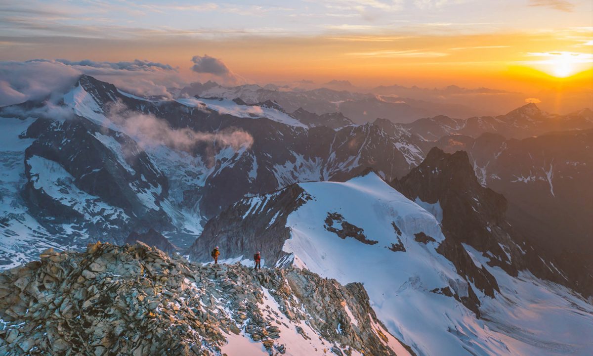 alpinistes marchant sur un crête au couché du soleil