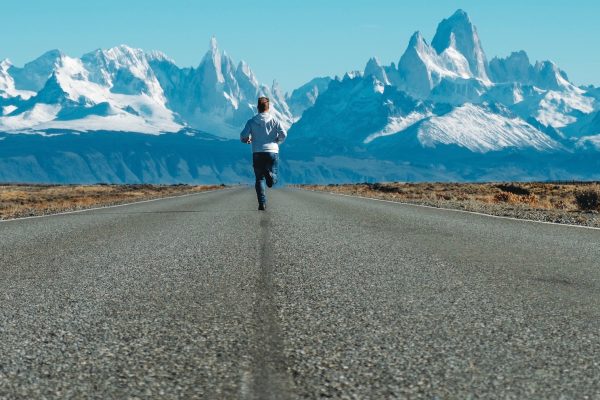 homme courant sur la route vers des montagnes enneigées Andrea Leopardi/Unsplash