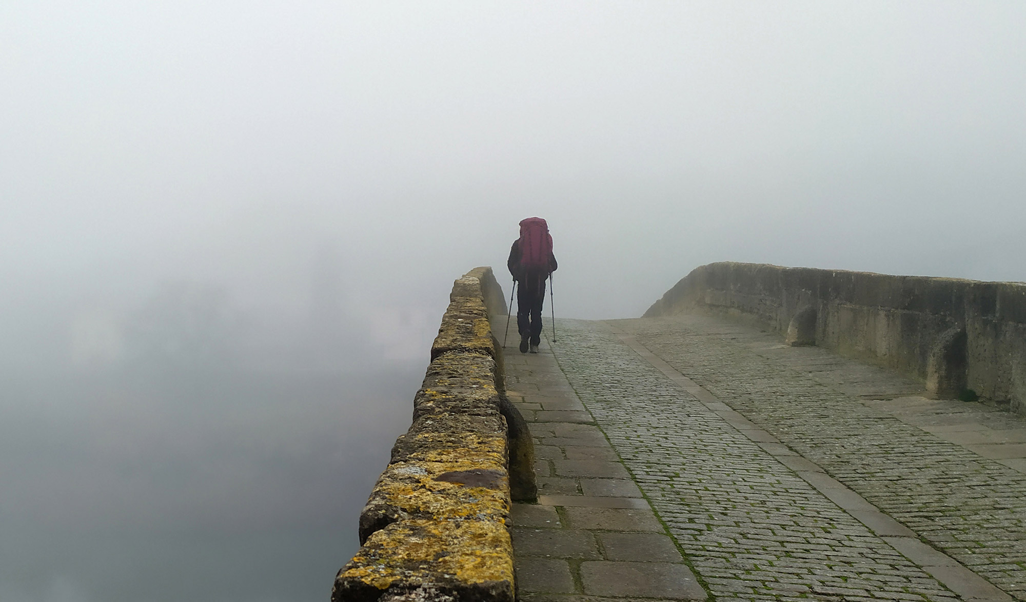 randonneurs sur un pont avec du brouillard