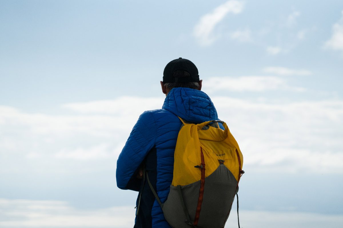 Mike Horn de dos avec vue sur un lac suisse