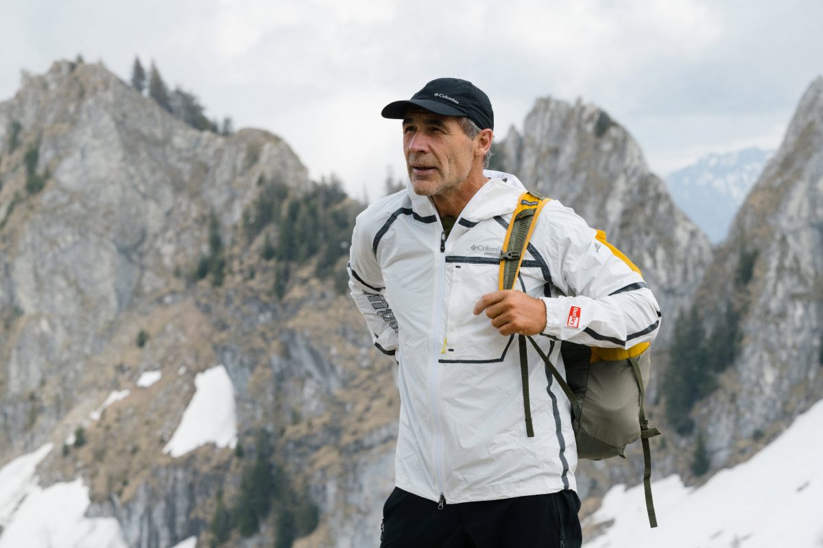 Mike Horn dans les montagnes Suisses mettant son sac à dos
