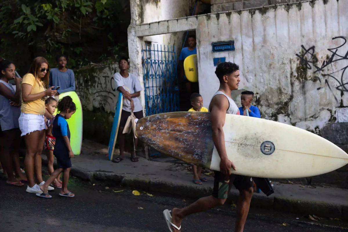 surfeur à pied dans les rues des favélas de Rio