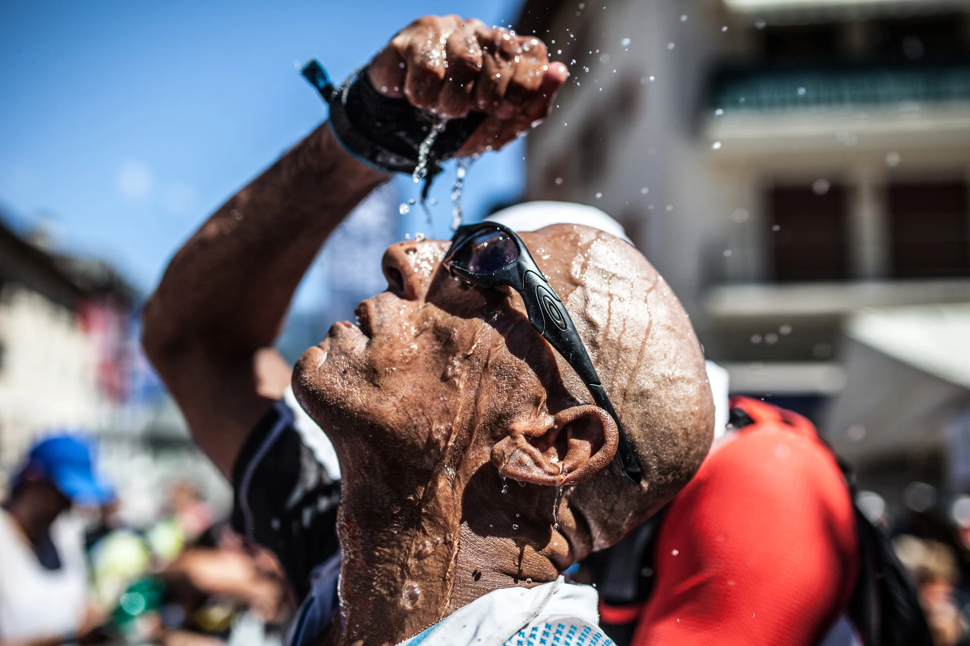 coureur UTMB se met de l'eau sur le visage pour se rafraichir