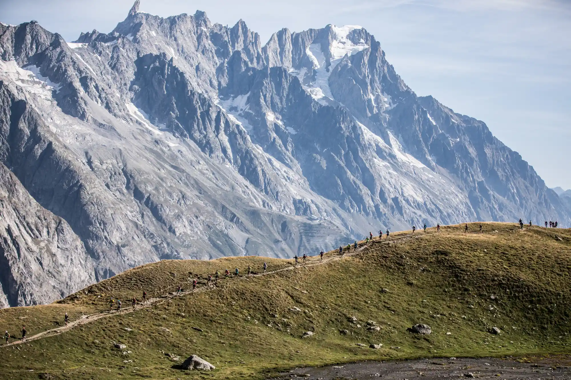 fil de coureurs de l'UTMB dans le Val Ferret devant la dent du Géant