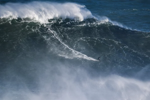 Lucas Chianca surf sur une tres grosse vague a Nazare au Portugal